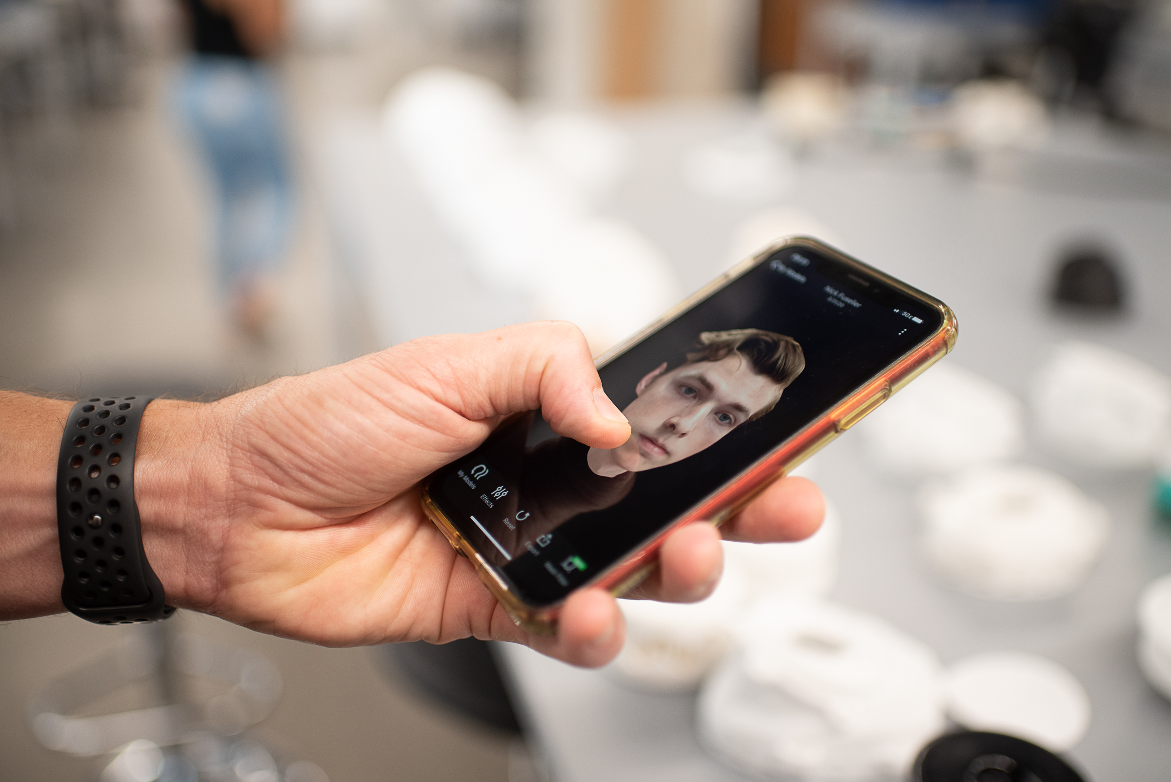 Scott Evans holds smart phone with 3D rendering of male face